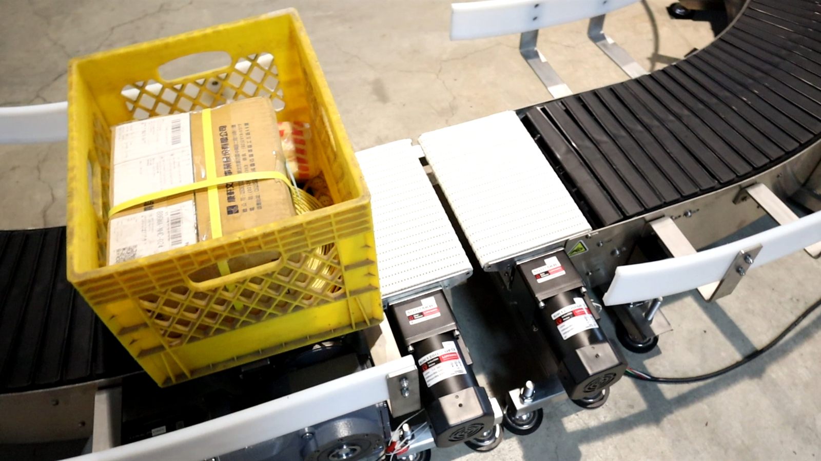 A plastic crate transferring from a spiral conveyor onto a curve.