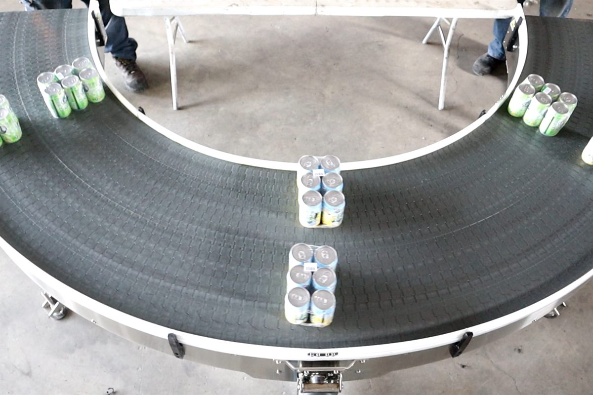 A curve conveyor carrying packed cans.