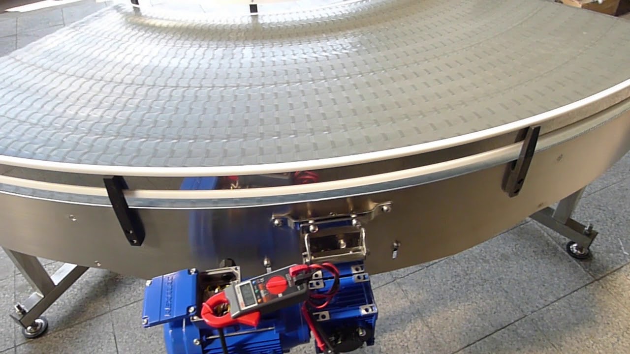 A wide curve conveyor with a white modular belt and a blue gearmotor.