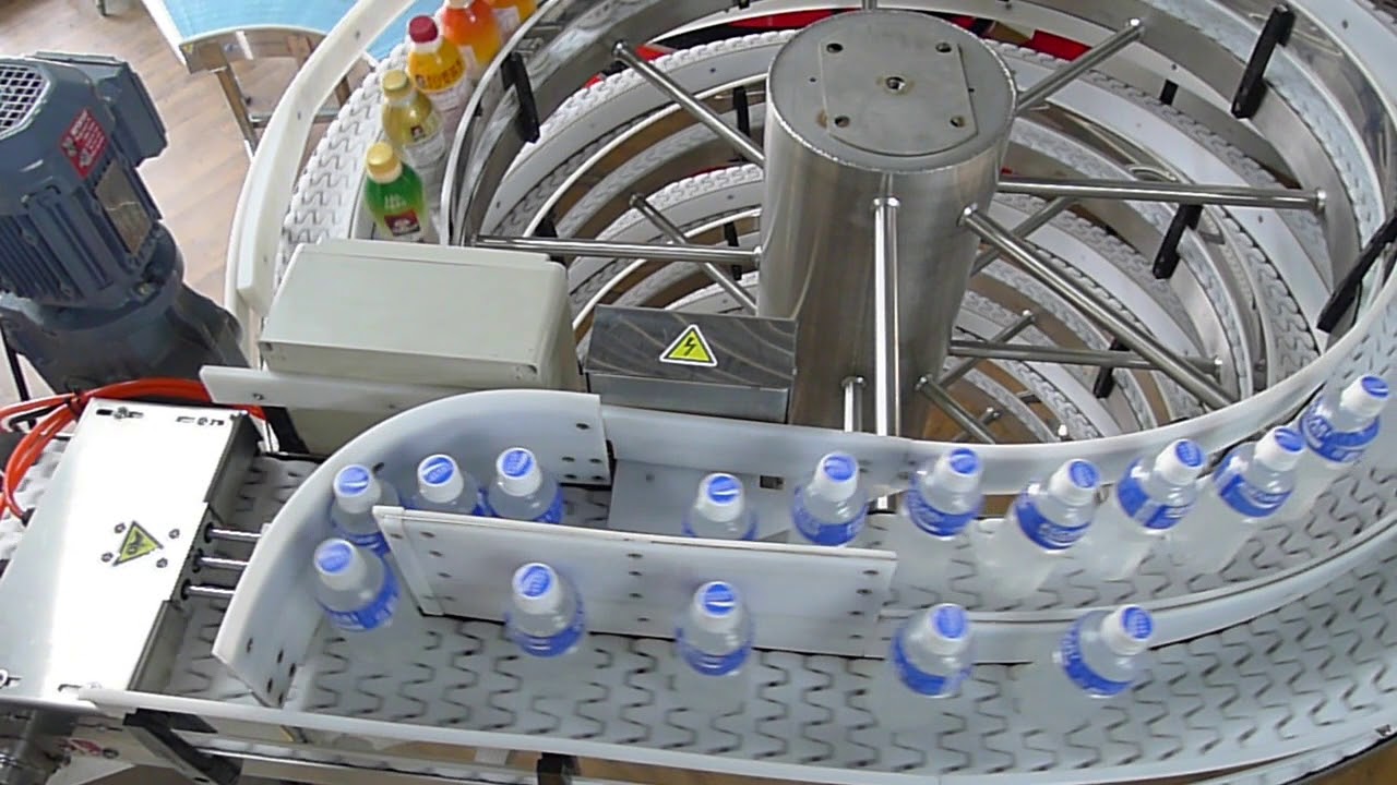 Water bottles on the inlet conveyor of a stainless steel spiral.
