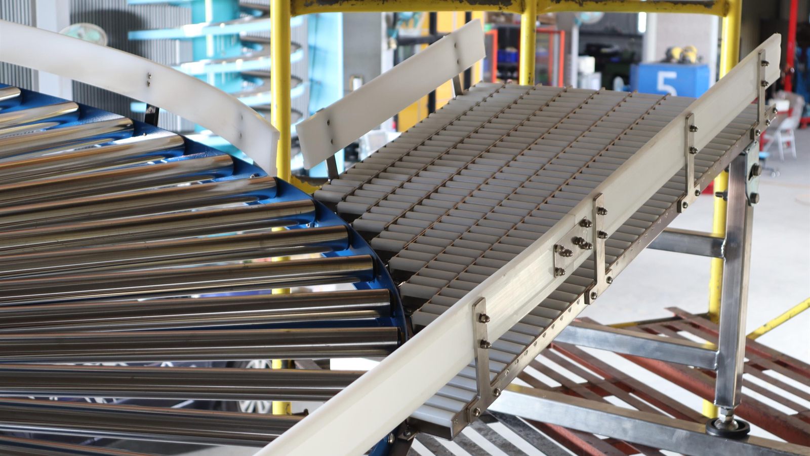 A NEXUS gravity roller spiral conveyor with unpowered rollers along the track.