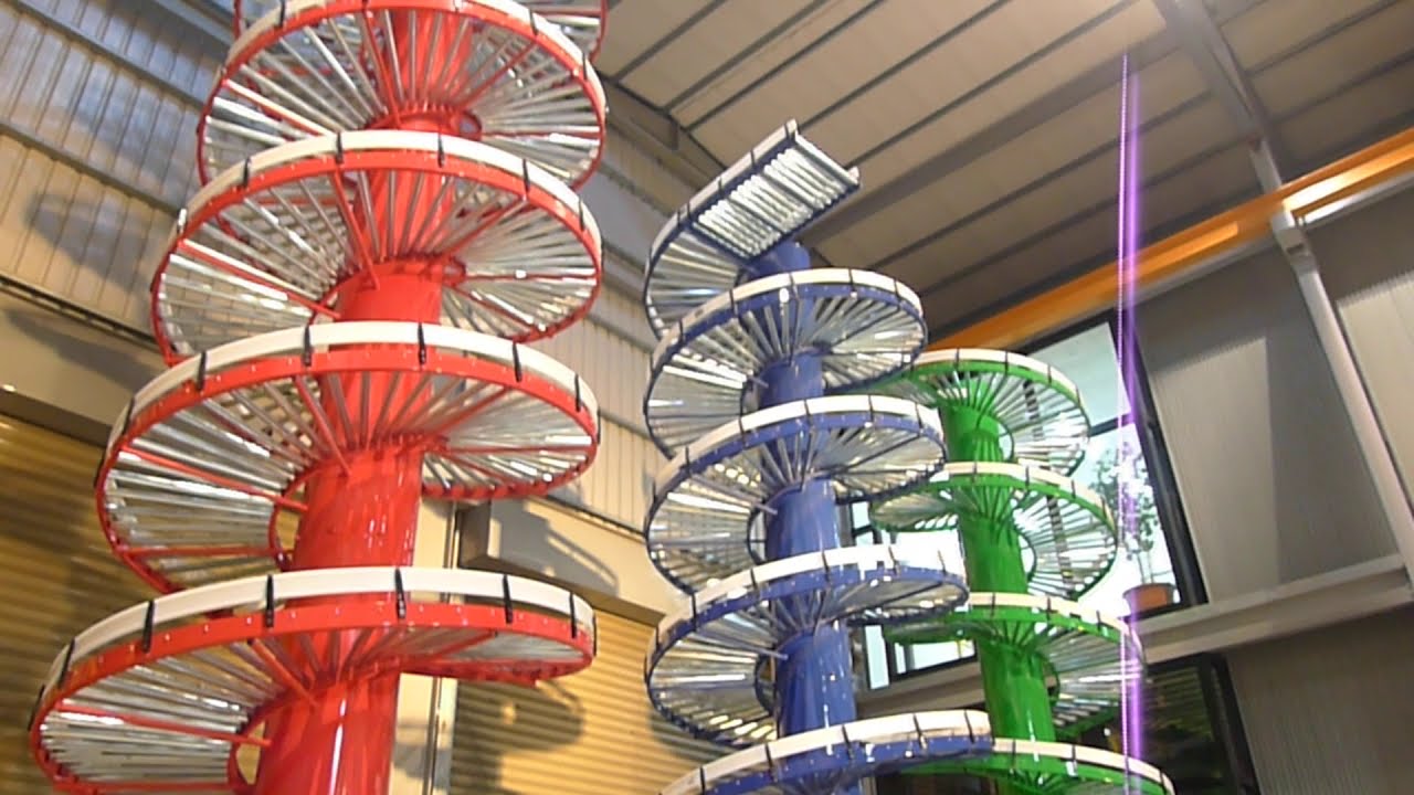 Three gravity roller spiral conveyors with red, blue and green columns in the NEXUS factory.