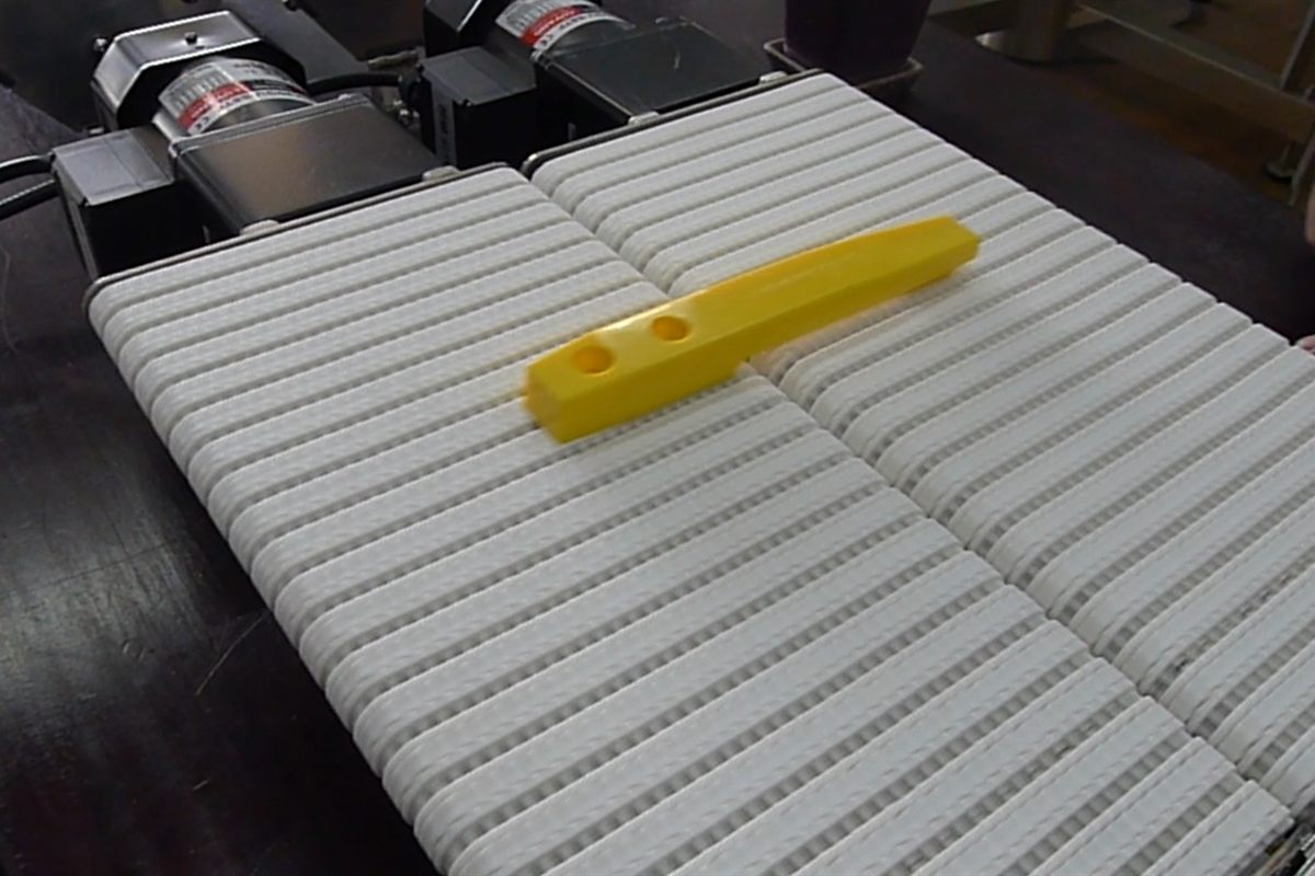 Miniature conveyors carrying small items between two machines.