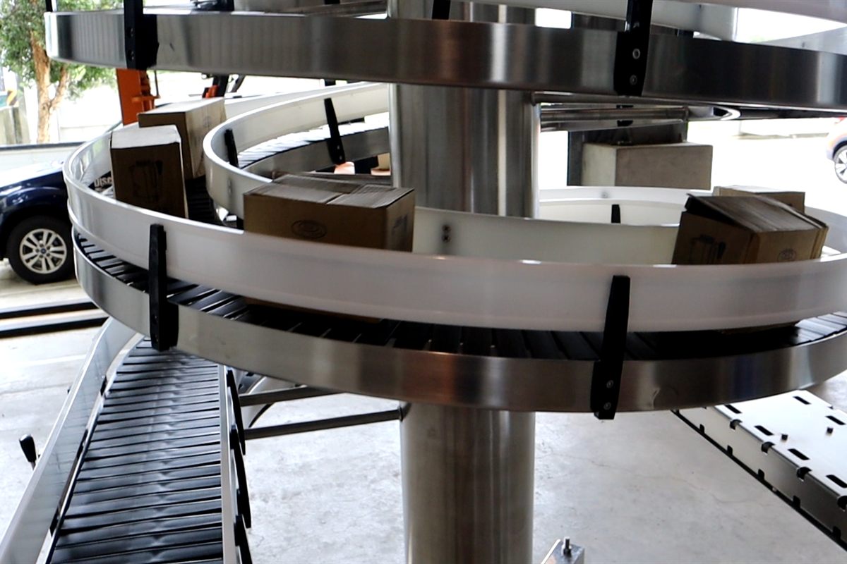 Cartons on the slat chain of a unit load spiral conveyor.
