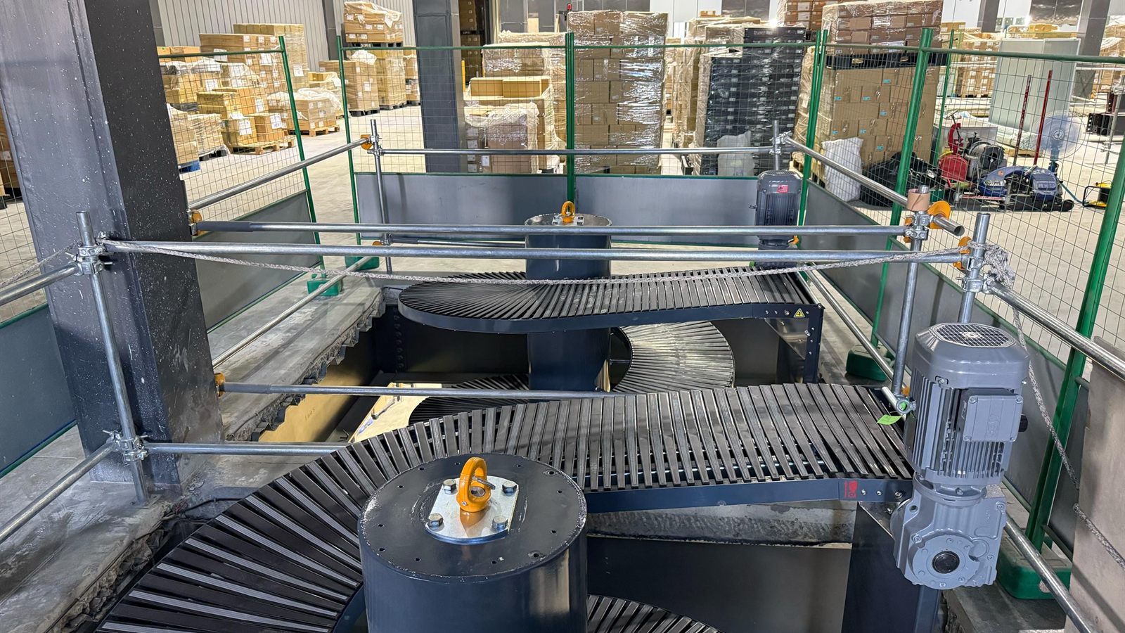 A spiral conveyor installed among racking in a distribution centre.